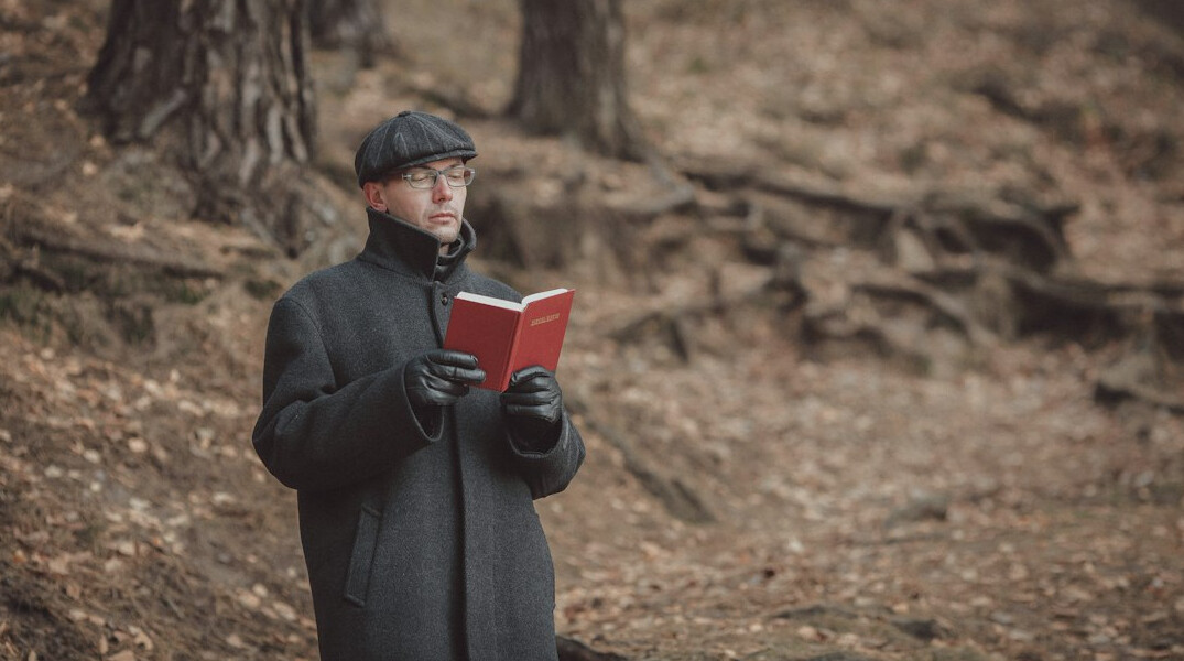 Uruguayan man in his thirties reading a notebook in a library